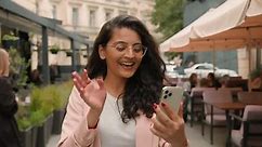 Happy smiling Indian Arabian ethnic woman girl female businesswoman tourist making video call talking greeting waving mobile phone camera outside city street cafe. Business online connection app Wi-Fi