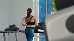Sporty young woman engages in treadmill workout at gym, slow motion. Embracing sport, fitness and a vibrant healthy lifestyle