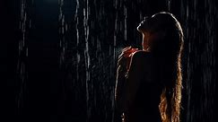 unrecognizable dark silhouette Young gorgeous woman fashion model posing in black water aqua studio shower, night sky rain drops. Adult girl beauty face long wet hair. red dress art video footage. 4k