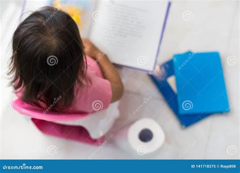 Potty Training. Toddler Sitting on the Toilet Reading a Book Stock ...