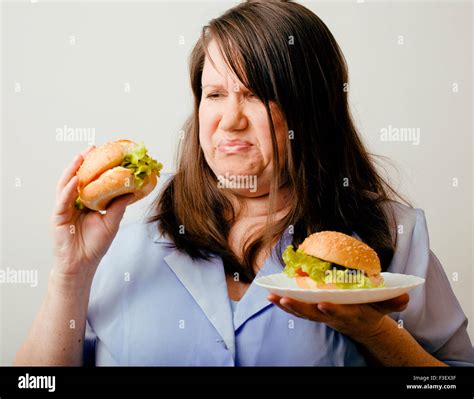 fat woman having choice between hamburger and salad Stock Photo - Alamy