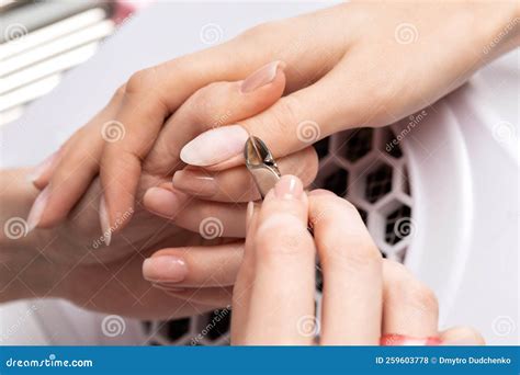 A Manicurist Removes Cuticles during a Nail Extension Procedure in a ...