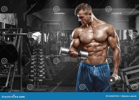 Muscular Man Working Out in Gym Doing Exercises with Dumbbells at ...