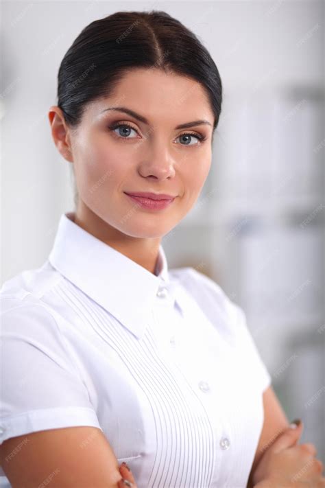 Premium Photo | Attractive businesswoman with her arms crossed standing in office