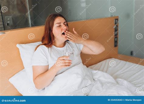 Healthy Beautiful Young Girl Holding Glass of Water on Bed at Home. Woman Waking Up in the ...