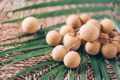 Premium Photo | Longan fruits over palm leaves on rattan background ...