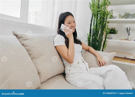 Young Asian Woman Smiling Sitting at Home on the Couch Relaxing and ...