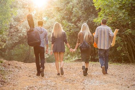 Premium Photo | Four friends walking on path in the forest