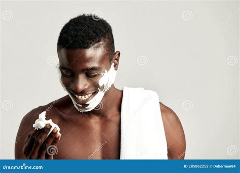 Studio Portrait of Handsome Black Guy with Naked Torso Applying Cream ...