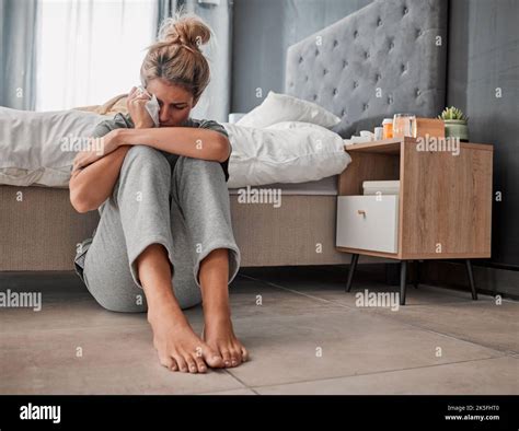 Crying, sad and depressed woman on bedroom floor using wipe for tears ...