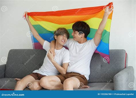 Young Asian Gay Couple Embracing and Holding Rainbow LGBT Flag Stock ...