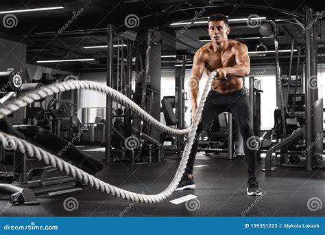 Muscular Man Working Out with Heavy Ropes in Gym. Strong Male Naked ...