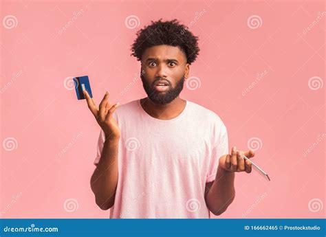 Confused Black Man Holding Credit Card and Cellphone Stock Image ...
