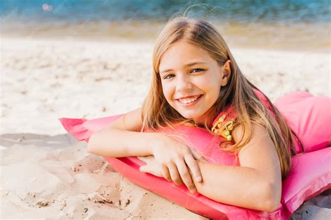 Free Photo | Smiling little girl relaxing on air mattress on beach in ...