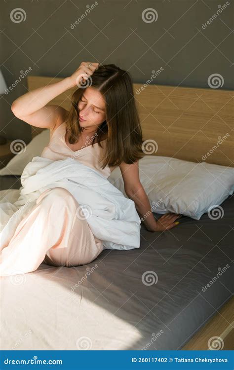 Girl is Waking Up in Morning with Hangover Stretches in Bed and Sun Shines from the Window ...