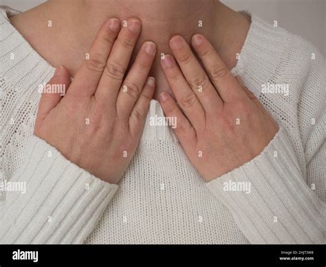 Sick women suffering from sore throat on gray background. Causes of throat pain include flu ...