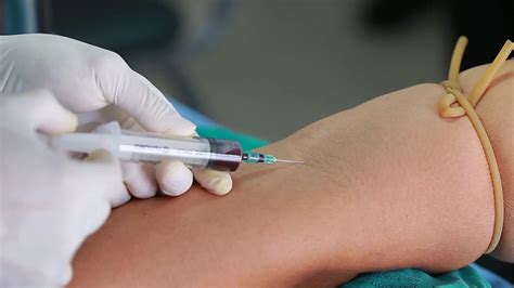 Lab technician holding blood tube sample for study, pricking needle ...
