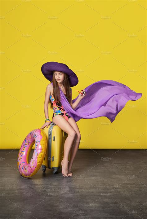 Stunning girl model in a colorful bikini hat pareo with a suitcase ...