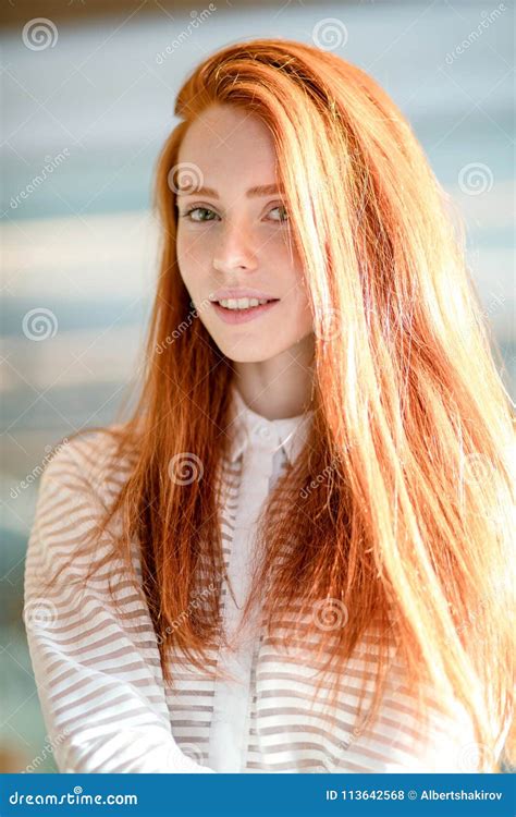 Cheerful Woman with Green Eyes and Red Hair in White Striped Blouse L ...