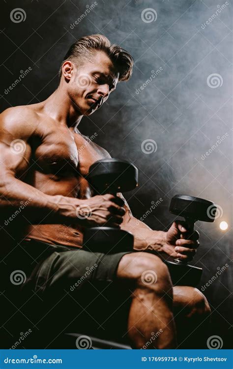 Muscular Fitness Model Working Out Biceps in Gym with Dumbbells Stock ...