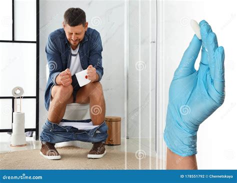 Doctor Holding Suppository for Hemorrhoid Treatment and Man Sitting on Toilet Bowl in Room Stock ...
