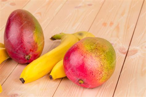 Premium Photo | Ripe mangoes and citrus fruits on the wooden table ...