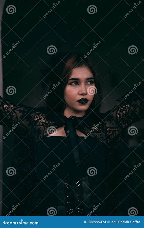 A Goth Asian Woman Dresses Up with Black Make Up and Wears Black Clothes Like a Scary Woman at ...