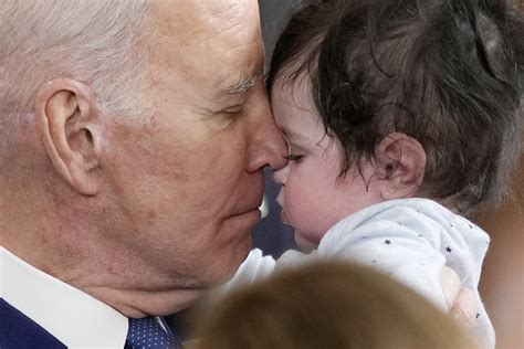 Biden hugs baby as WH fixes gaffe on disarming 'political advisers'