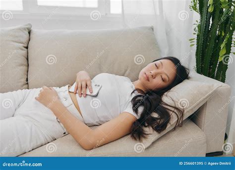 Young Asian Woman Sleeping on the Couch at Home with Her Eyes Closed, Very Tired and Resting To ...