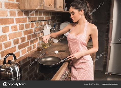 Sexy Young Woman Apron Pouring Oil Frying Pan Kitchen Stock Photo by ©DmitryPoch 177921510