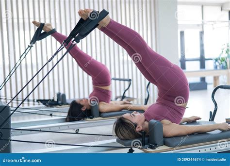 Two Young Asian Women Doing Pilates Exercises on a Reformer. Stock ...