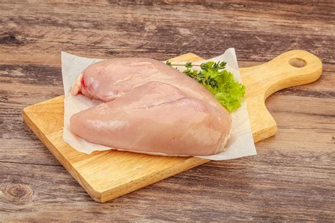 Premium Photo | Raw chicken breast over board