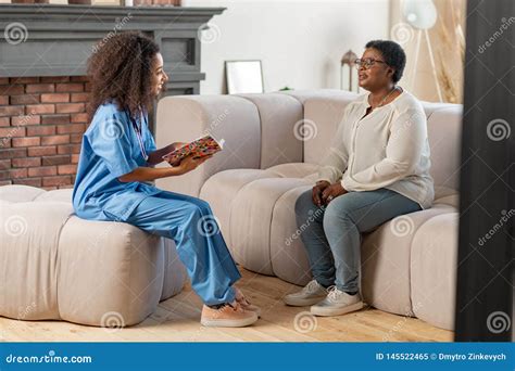Aged Lady Sitting on Sofa and Answering the Questions of Private Nurse ...