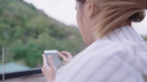 Modern teenager enjoy using mobile app sitting in cafe against the hill, young blond lady sliding on social media enjoys looking at new feeds of her friends, stay with natural healing mental turmoil