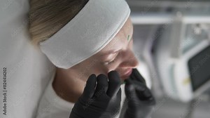 Beautiful young woman at the appointment of a cosmetologist, woman inserting needles in the face of a clinic to work out problem areas,
