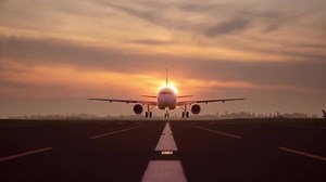 Commercial Airplane Takes Off from Runway at Sunset
