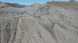 The caldera and the peak of Mount Bromo from a height. It looks like the tourists are climbing and enjoying the peak. Mt.Bromo is a popular tourist destination in East Java, Indonesia