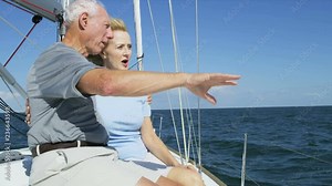 Mature American male and female outdoors on their sailing boat enjoying their vacation and retirement living