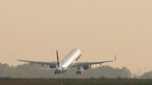 Download Footage of a commercial jet taking off. The airliner with an unrecognizable livery is backlit for free