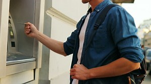 clip-31515505-young-handsome-man-using-atm-machine-outdoors