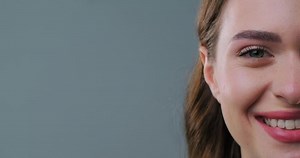 Beautiful woman smiling on light grey background, closeup