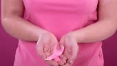 Video of midsection of caucasian woman holding pink cancer awareness...