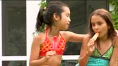 MS Two girls eating frozen popsicles side by side and giving thumbs...