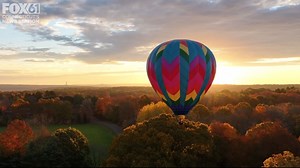 Hot air balloon over fall foliage during Connecticut sunrise | Sky61