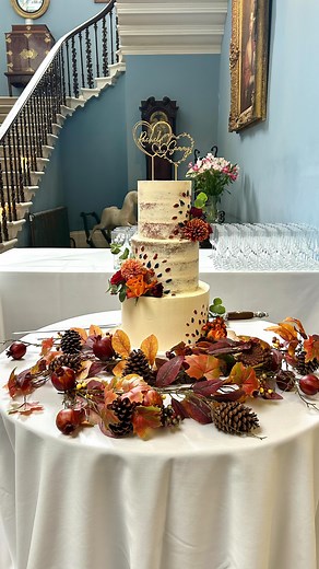 Rachel & Sammy 💙🧡❤️ Semi-naked buttercream wedding cake with a little buttercream art, fresh flowers and personalised topper. Also 5 furry friends making a little appearance at the back of cake. We also did biscuit favours to match and a few specialist cupcakes for allergen guests. Set up @drenaghweddings | Lou's Cake Design