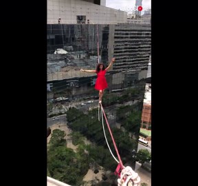 'Brazilian yoga trainer & athlete walks a highline above a São Paulo street '
