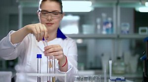 Female scientist working in chemical laboratory. Scientist close test tubes