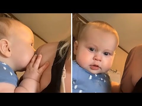 Baby adorably mesmerized by mom's colorful tattoo