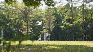 two asian children playing with kid outdoors in park while parents watching from behind