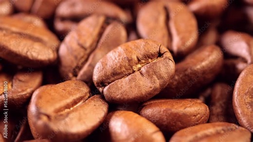 Coffee background. close up of roasted coffee beans with smoke rising and zoom in motion. Harvesting coffee fruits. Roasted beans close-up. Space for your text.